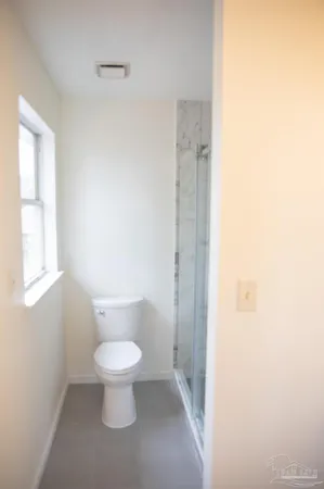 a white toilet sitting next to a bathroom sink and vanity
