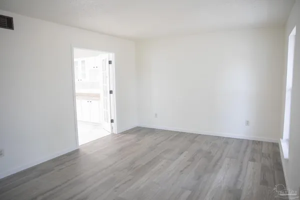 a view of an empty room with wooden floor