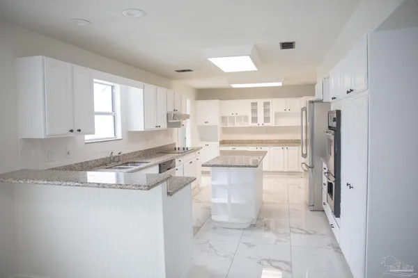 a kitchen with a refrigerator sink and cabinets