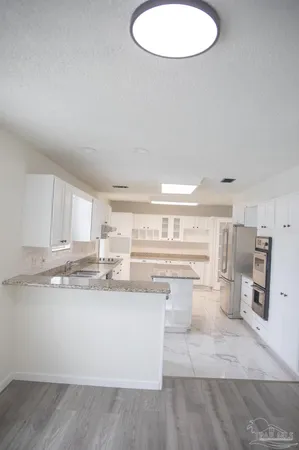a kitchen with stainless steel appliances granite countertop a stove a sink and a refrigerator