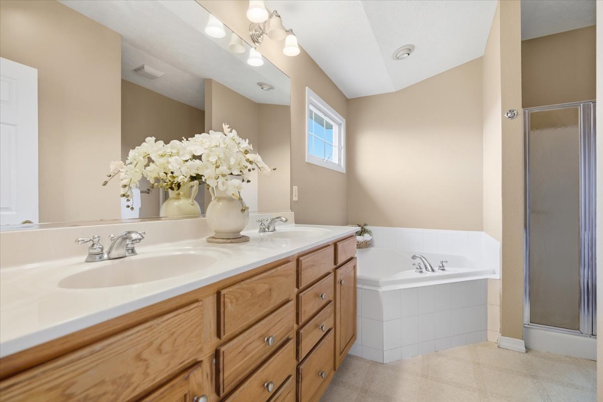 3255 Fire Fly Court Normal, IL 61761 - Photo 13 of 25 a bathroom with a sink double vanity granite tub shower and a mirror