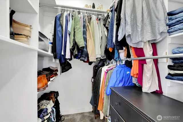 a view of walk in closet with clothes and shoes