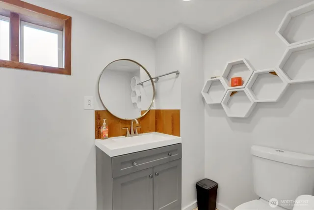 a bathroom with a sink mirror and toilet