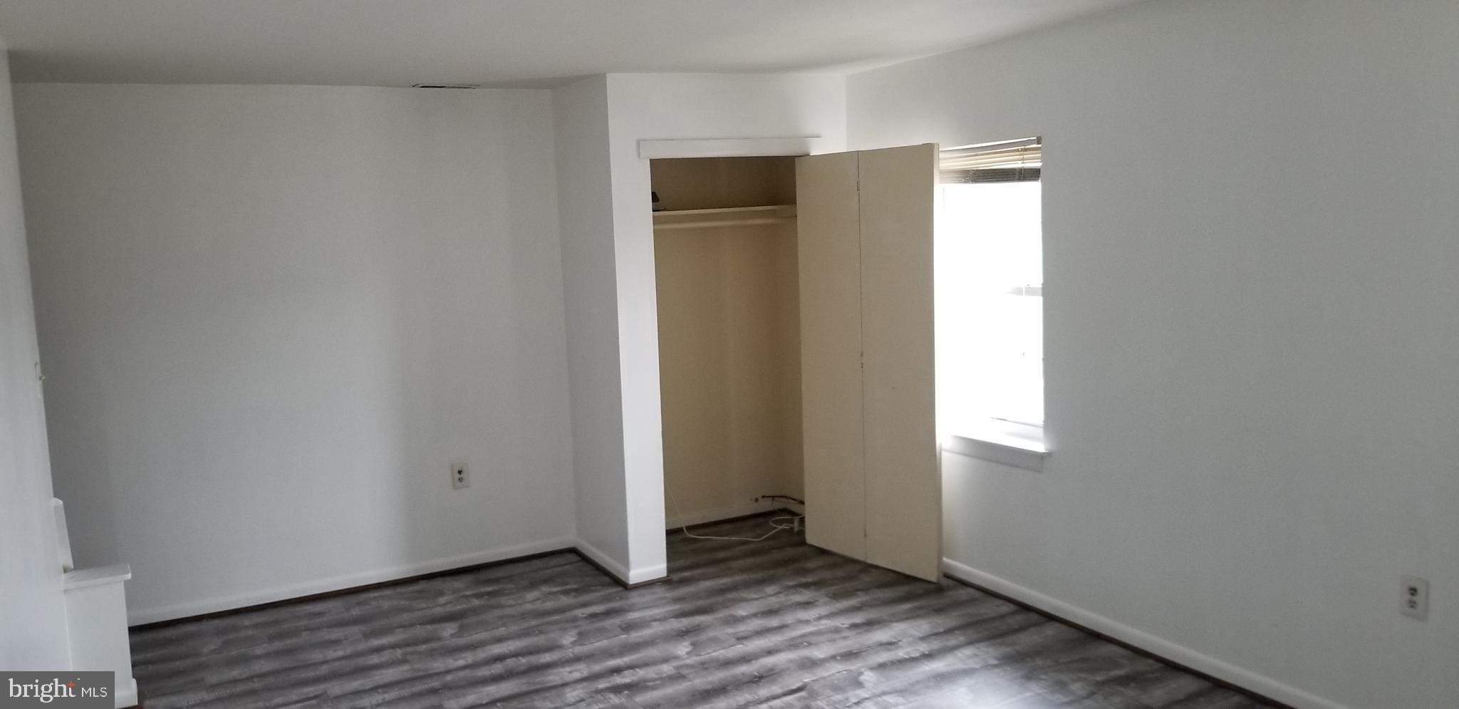 581 Fish Pond Road, Unit UP Glassboro, NJ 08028 - Photo 6 of 10 a view of an empty room with wooden floor and closet