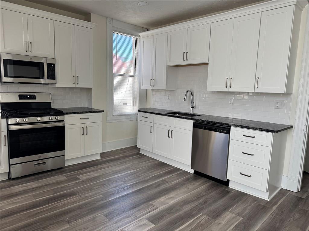 94 South 18th Street, Unit 2 Pittsburgh, PA 15203 - Photo 9 of 20 a kitchen with stainless steel appliances granite countertop a stove a sink and white cabinets