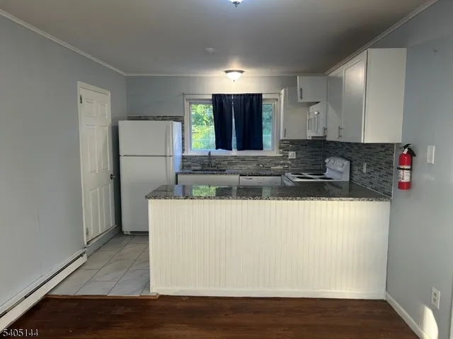a view of kitchen with stainless steel appliances granite countertop white refrigerator a stove top oven a sink and dishwasher