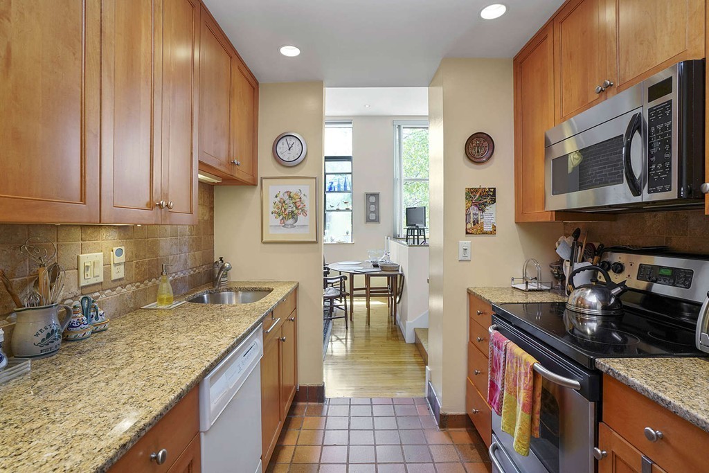 145 St Botolph Street, Unit 21 Boston, MA 02115 - Photo 8 of 23 a kitchen with stainless steel appliances granite countertop a stove a sink and a microwave