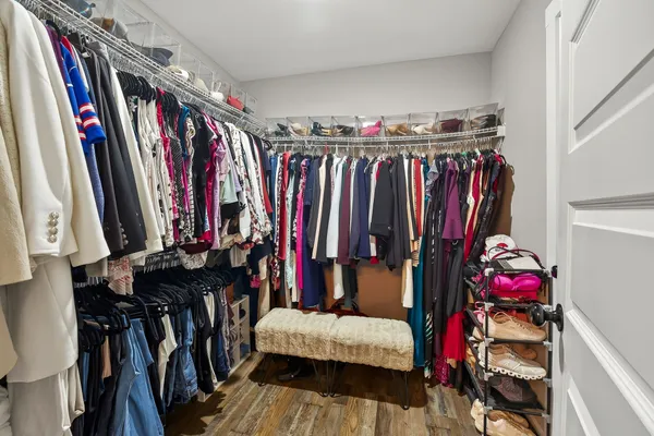 a view of walk in closet with clothes