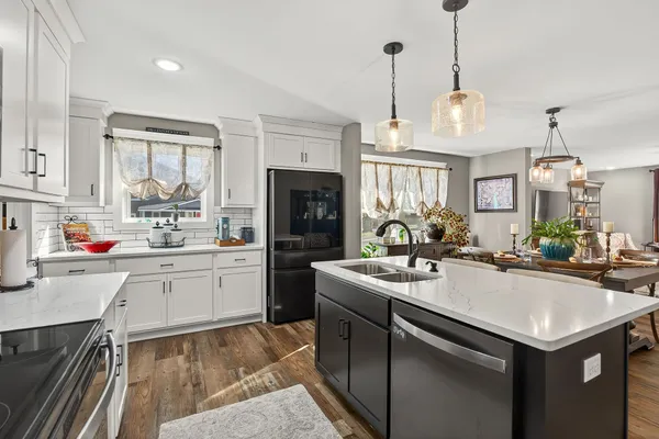 a kitchen with a sink a stove and chairs
