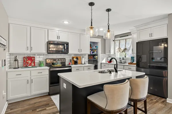a kitchen with sink a microwave and cabinets