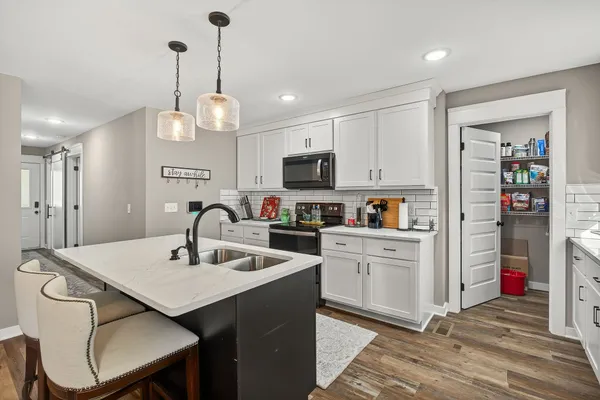 a kitchen with a center island appliances and cabinets