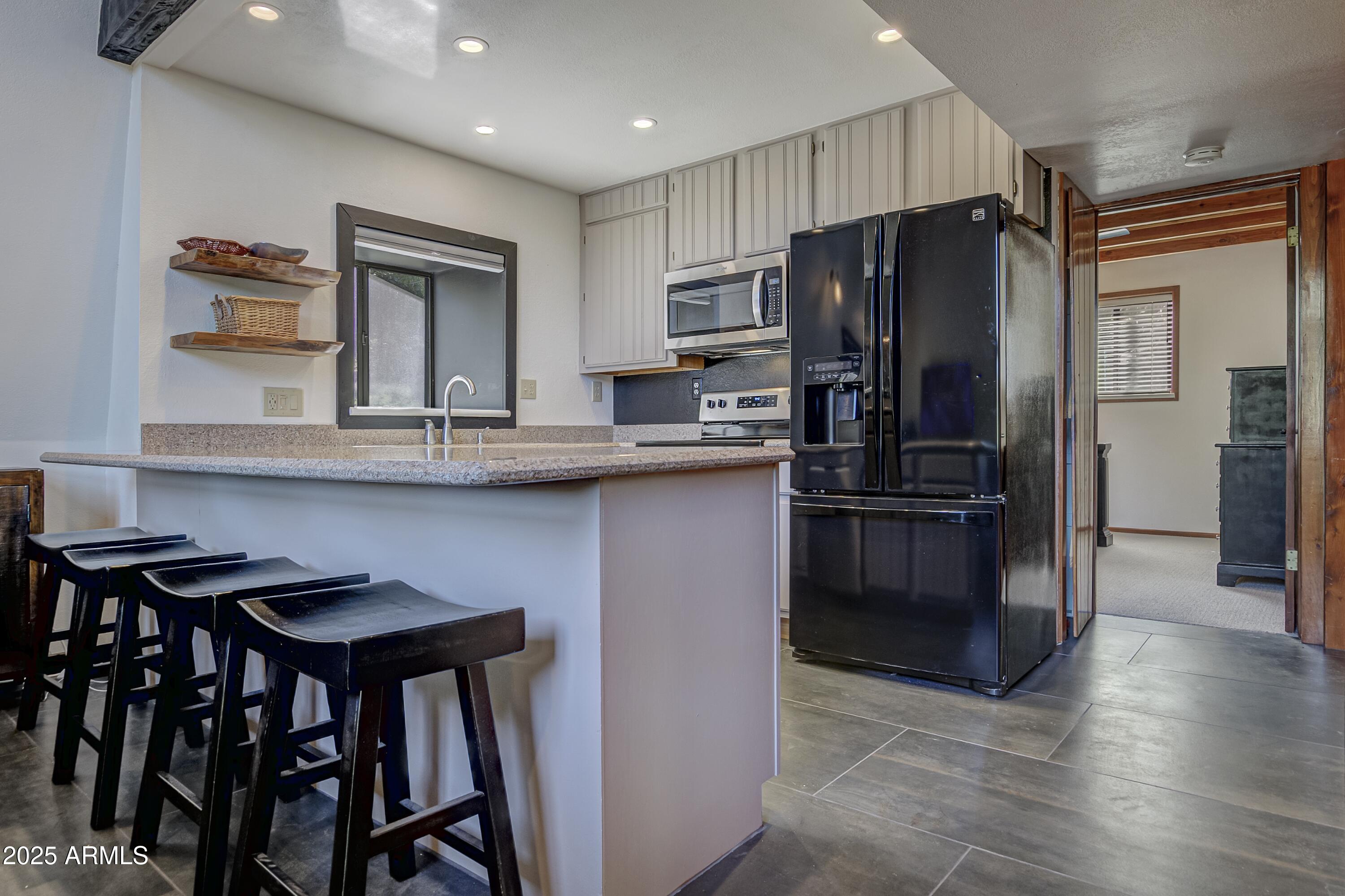 4763 Ernies Road Strawberry, AZ 85544 - Photo 8 of 50 a kitchen with kitchen island a refrigerator stove and microwave