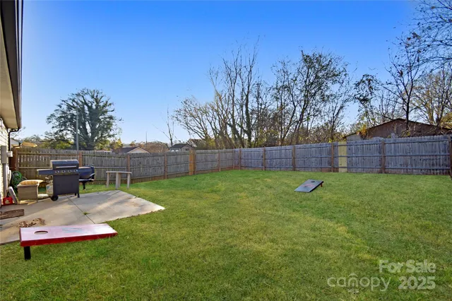 a view of yard with swimming pool and wooden fence