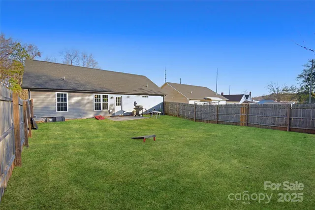 a view of a house with backyard and a tree