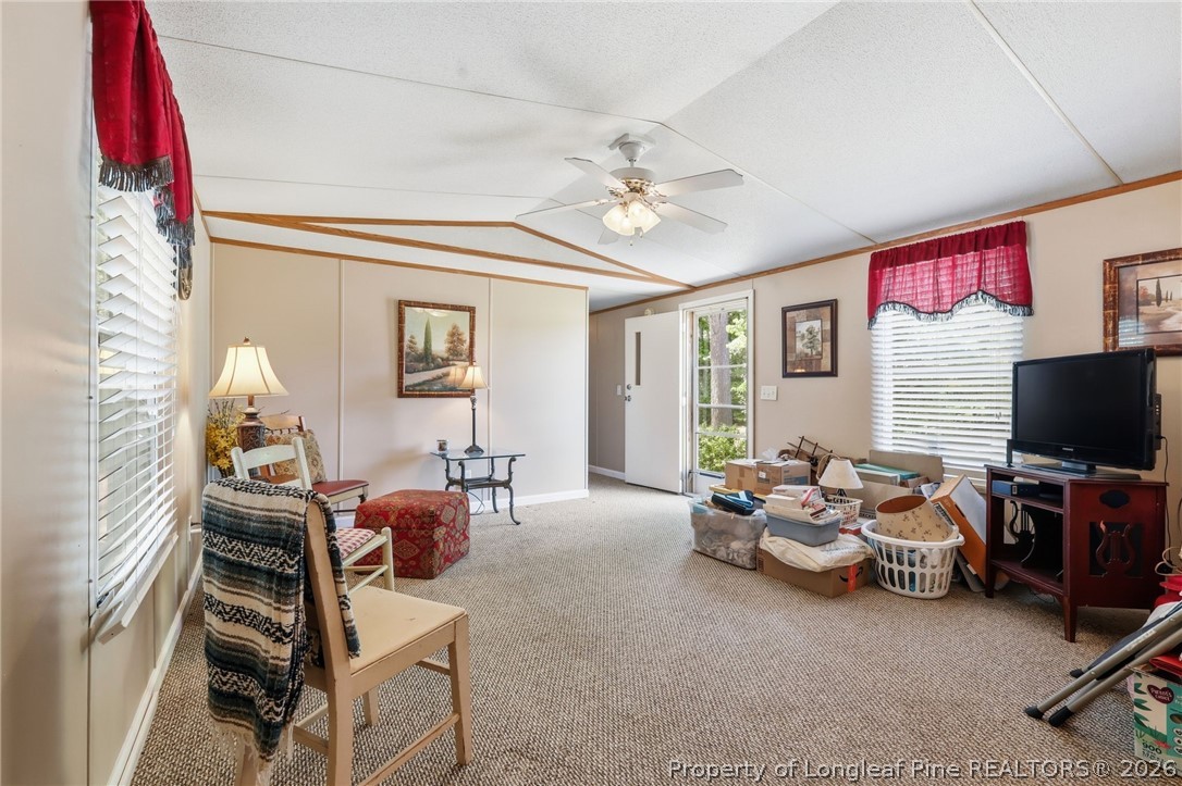10400 Ruth Vinson Road Autryville, NC 28318 - Photo 42 of 49 a living room with furniture a flat screen tv and gym equipment