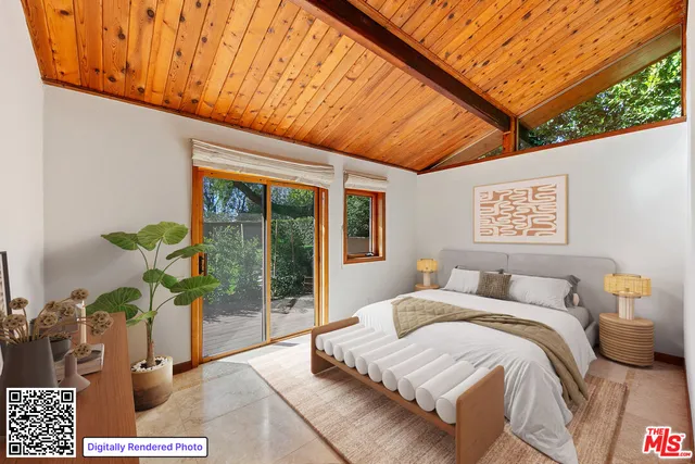 a large bedroom with a large bed a flat tv screen and a potted plant