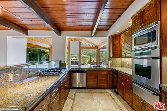 a kitchen with stainless steel appliances granite countertop a stove and a refrigerator