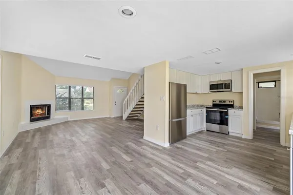 a kitchen with granite countertop a refrigerator stove top oven and sink