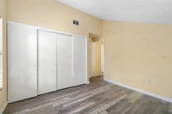 an empty room with windows and closet