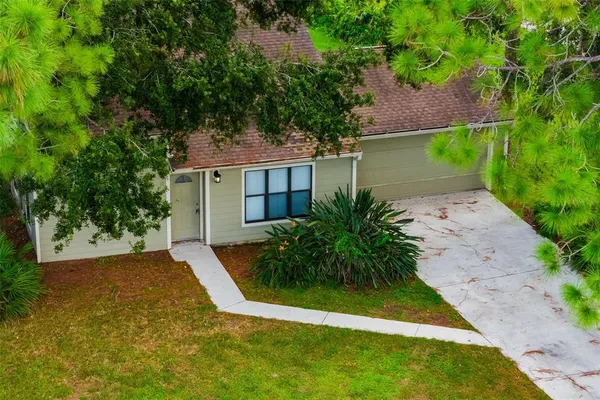 an aerial view of residential house with outdoor space and trees all around