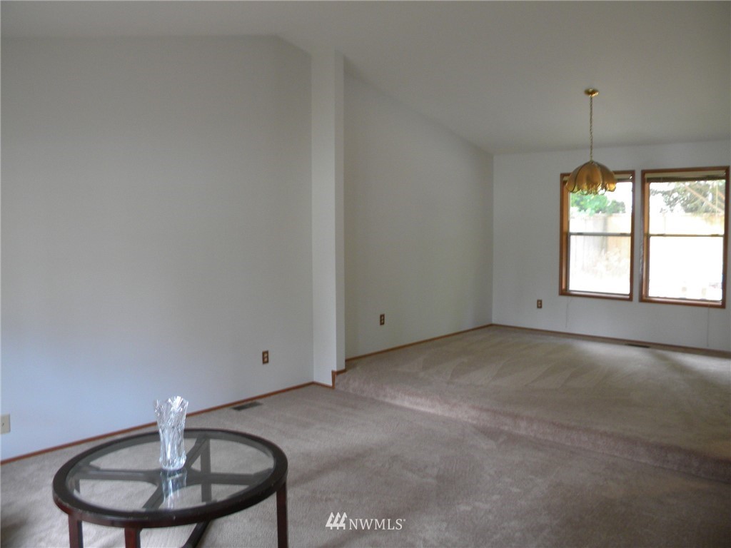 3107 164th Place Southeast Bothell, WA 98012 - Photo 8 of 20 a view of an empty room with a window and chandelier