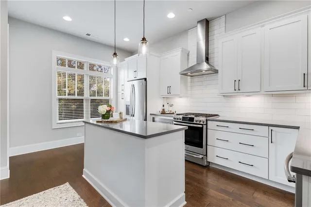 a kitchen with stainless steel appliances granite countertop a sink a stove and a refrigerator