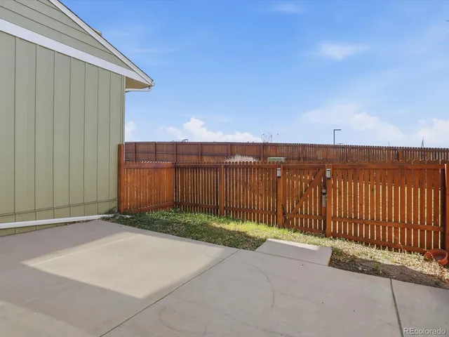 a view of backyard with wooden fence