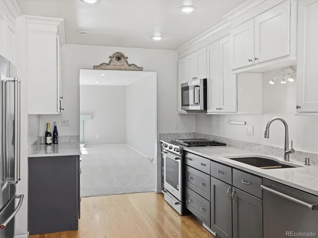 a kitchen with stainless steel appliances granite countertop a sink stove and refrigerator