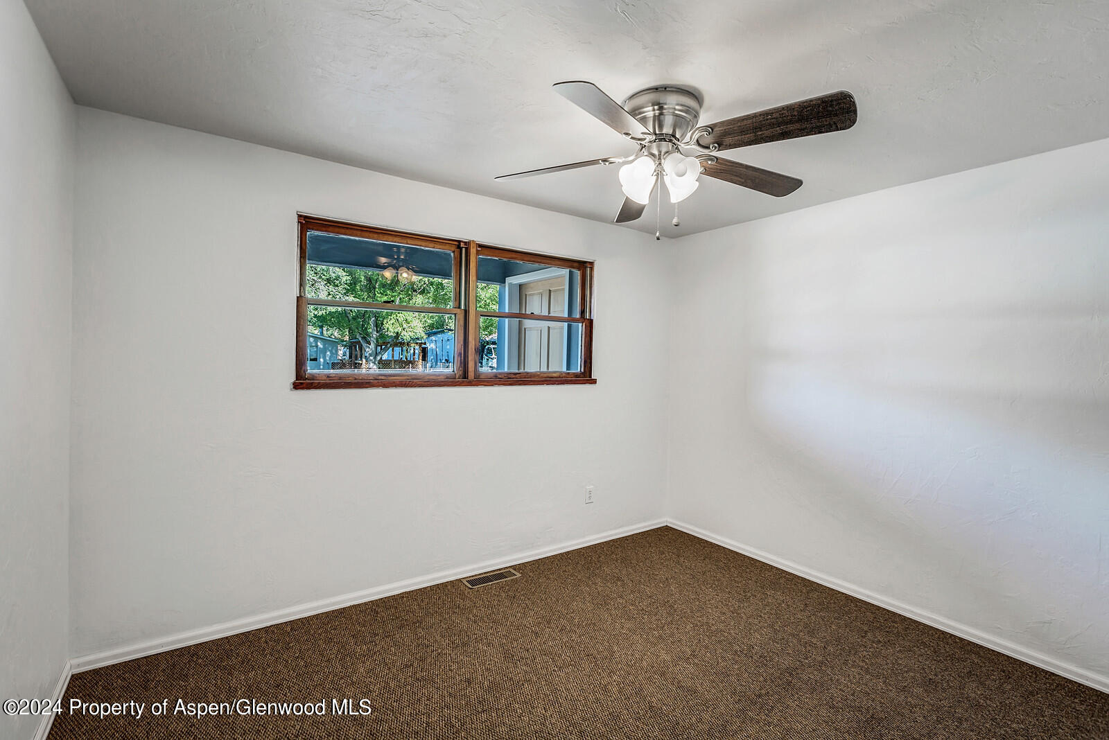 902 Randolph Avenue Rifle, CO 81650 - Photo 7 of 18 an empty room with a window and a fan