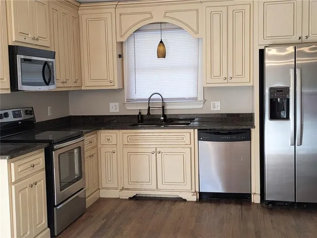 a kitchen with granite countertop white cabinets and stainless steel appliances