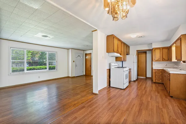 a view of a kitchen with furniture and wooden floor