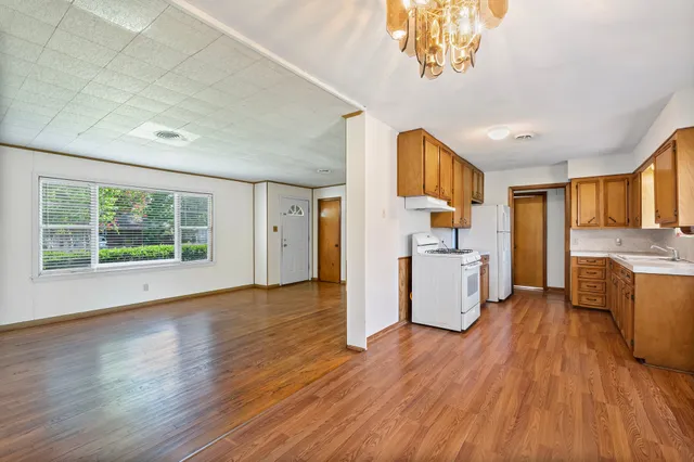 a view of a kitchen with furniture and wooden floor