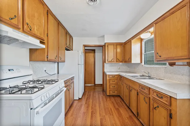 a kitchen with a sink stove and cabinets