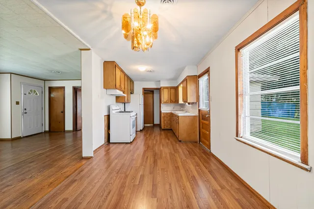 a view of a kitchen with a fridge wooden floor and a window