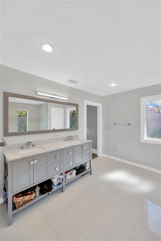 2802 Northpointe Lane Tampa, FL 33611 - Photo 25 of 55 a spacious bathroom with a double vanity sink and a mirror