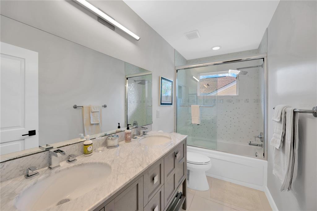 2802 Northpointe Lane Tampa, FL 33611 - Photo 31 of 55 a bathroom with a double vanity sink toilet mirror and shower