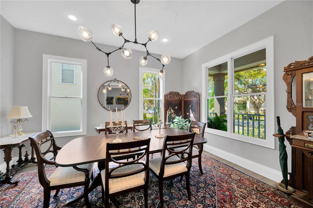2802 Northpointe Lane Tampa, FL 33611 - Photo 38 of 55 a dining room with wooden floor a chandelier a wooden table and chairs