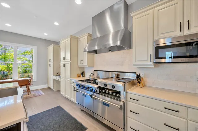a kitchen with stainless steel appliances granite countertop a sink stove and cabinets