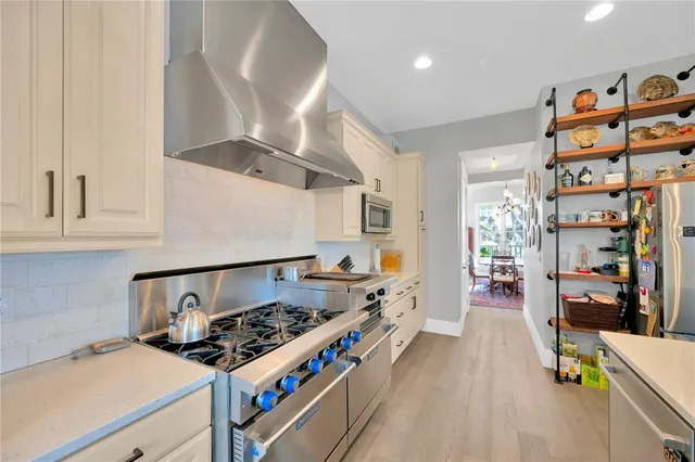 a large kitchen with kitchen island a large counter space windows and stainless steel appliances