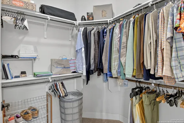 a view of walk in closet with clothes and shoes