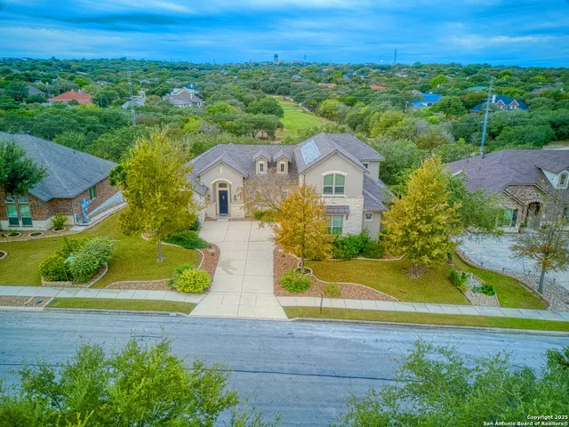 an aerial view of residential houses with outdoor space and trees