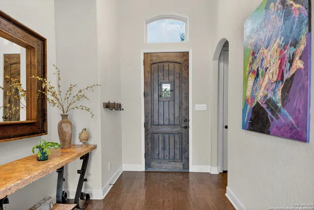 a view of a hallway to a livingroom with furniture and wooden floor