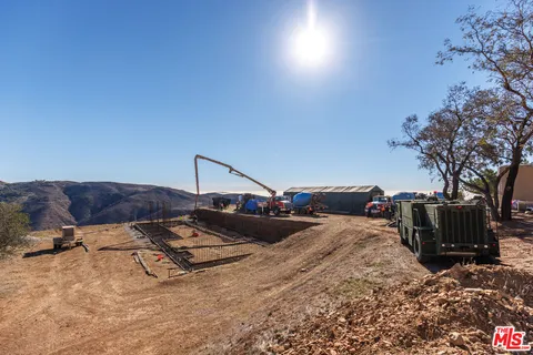 a view of roof deck with two couches and potted plants