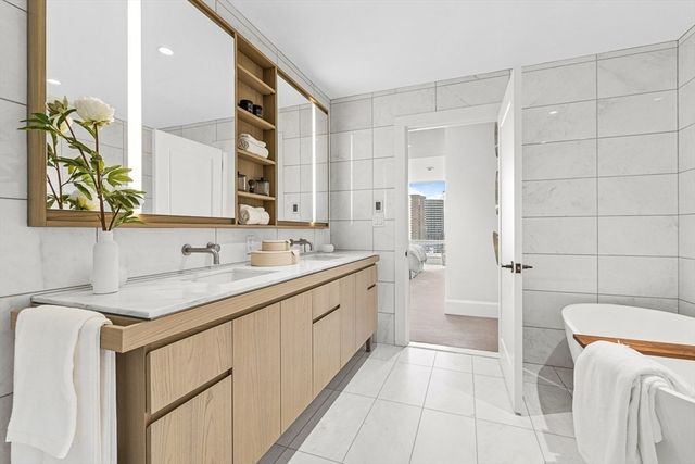 a bathroom with a granite countertop sink a toilet a mirror and shower