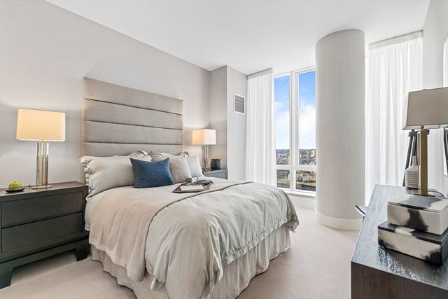 a bedroom with a bed flat screen tv and a large window