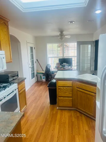 a kitchen with stainless steel appliances granite countertop a stove a sink dishwasher and a microwave oven with white cabinets