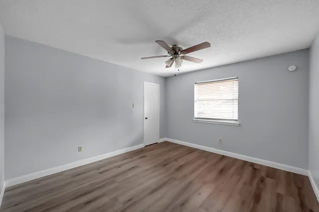 a view of a room that has wooden floor and a window