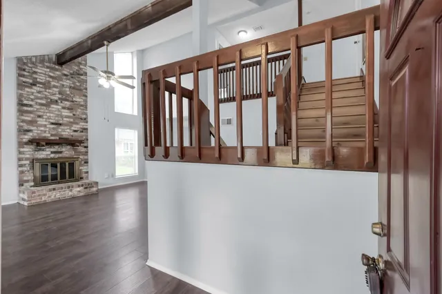 a view of staircase with wooden floor and a fireplace