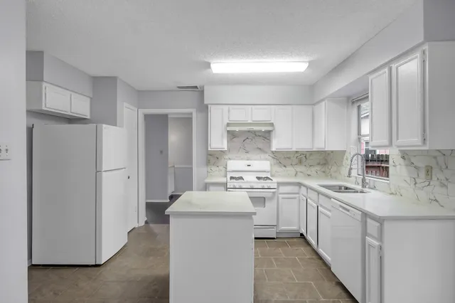 a kitchen with a sink stove and refrigerator