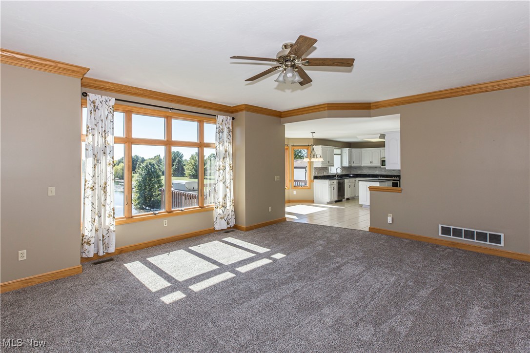 1570 Reimer Road Wadsworth, OH 44281 - Photo 9 of 48 Unfurnished living room featuring ornamental molding, a ceiling fan, and light carpet